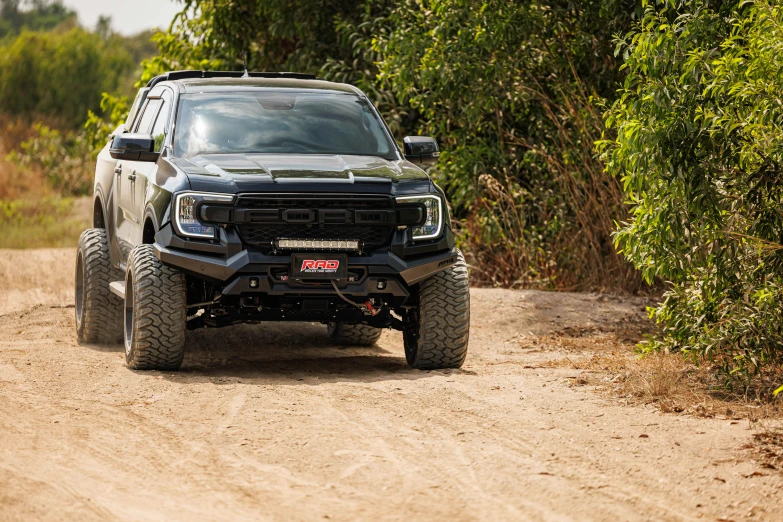 a truck driving on dirt road with trees in the background