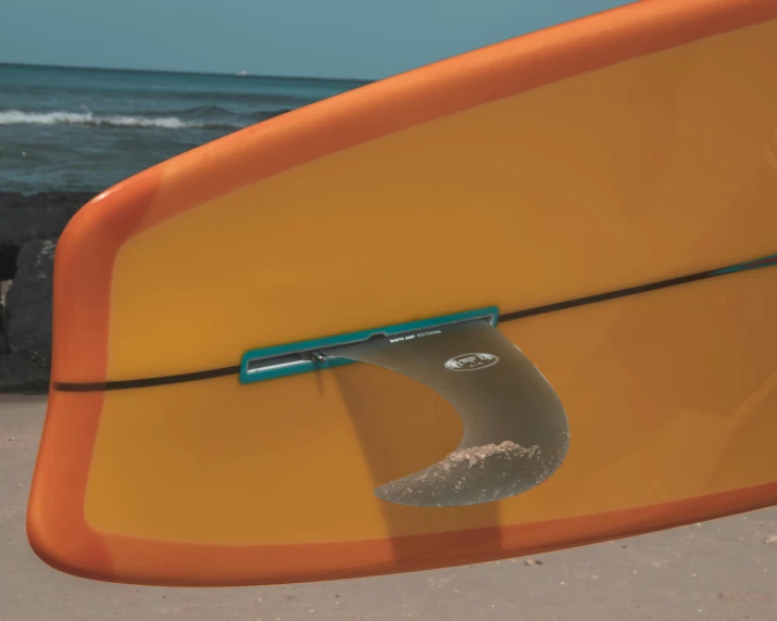 the surf board is standing in the sand