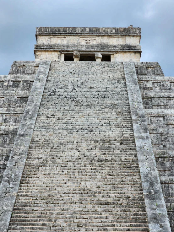 large stairway in the middle of a pyramid on cloudy day