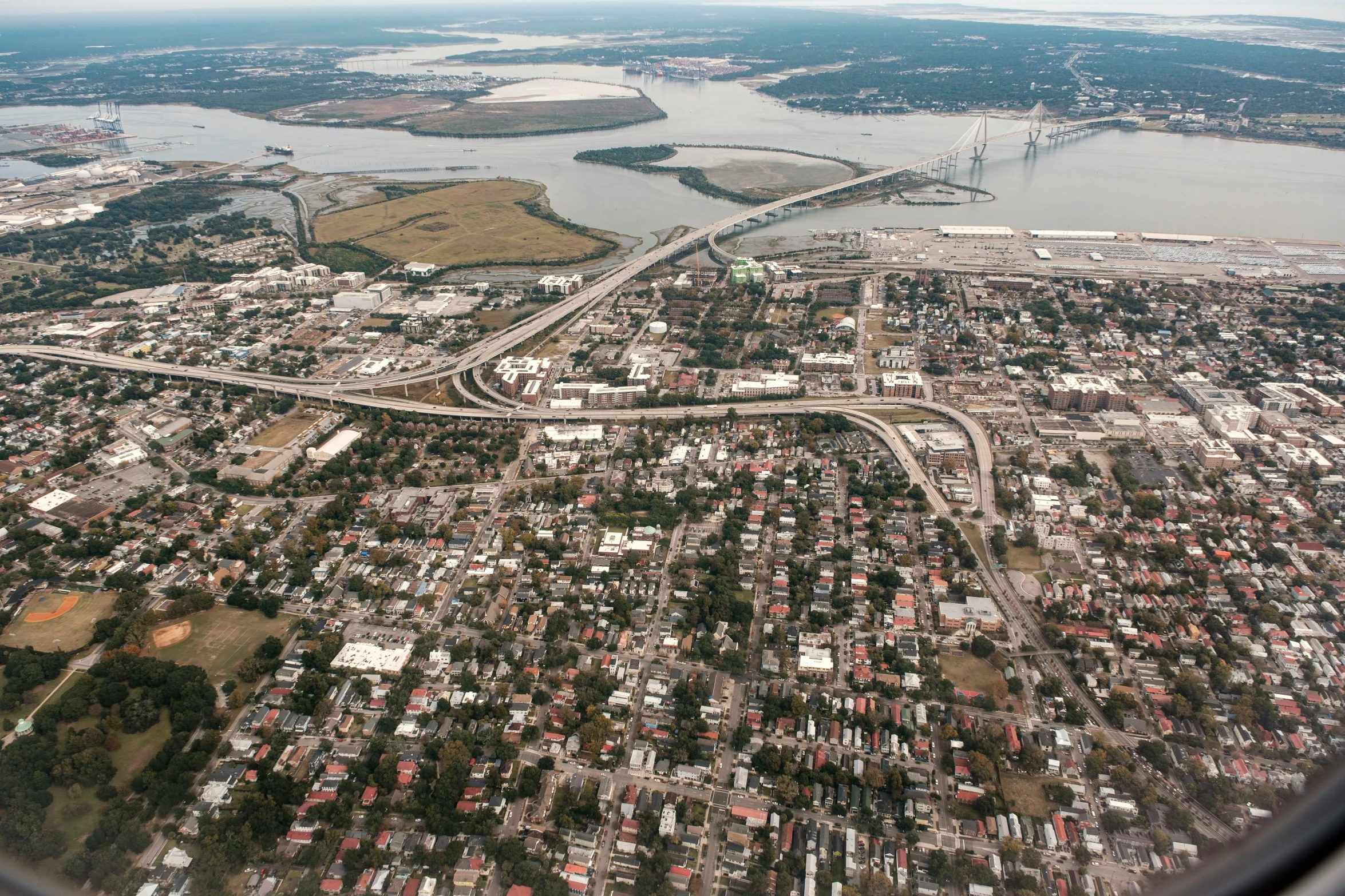 a picture taken from a window plane of a town in an area with rivers and islands