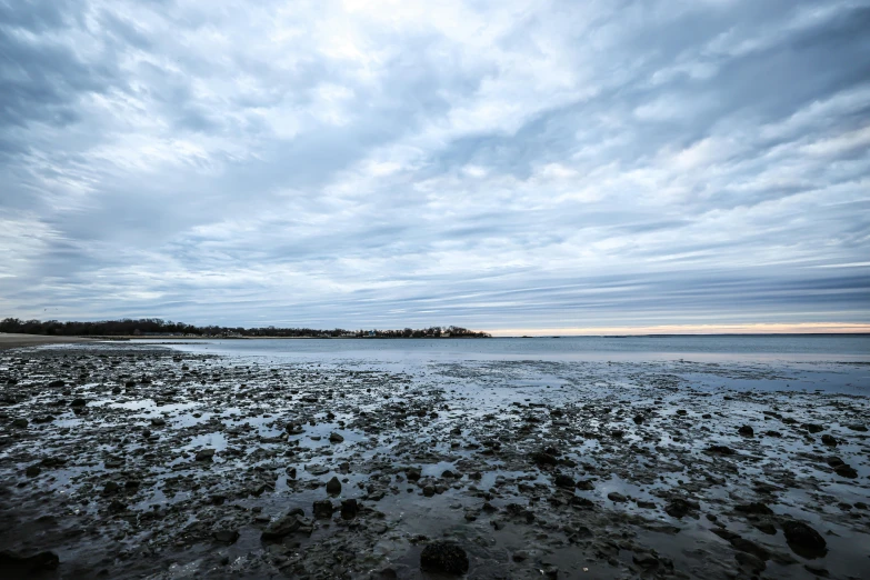 the sky is blue and cloudy above a sandy beach