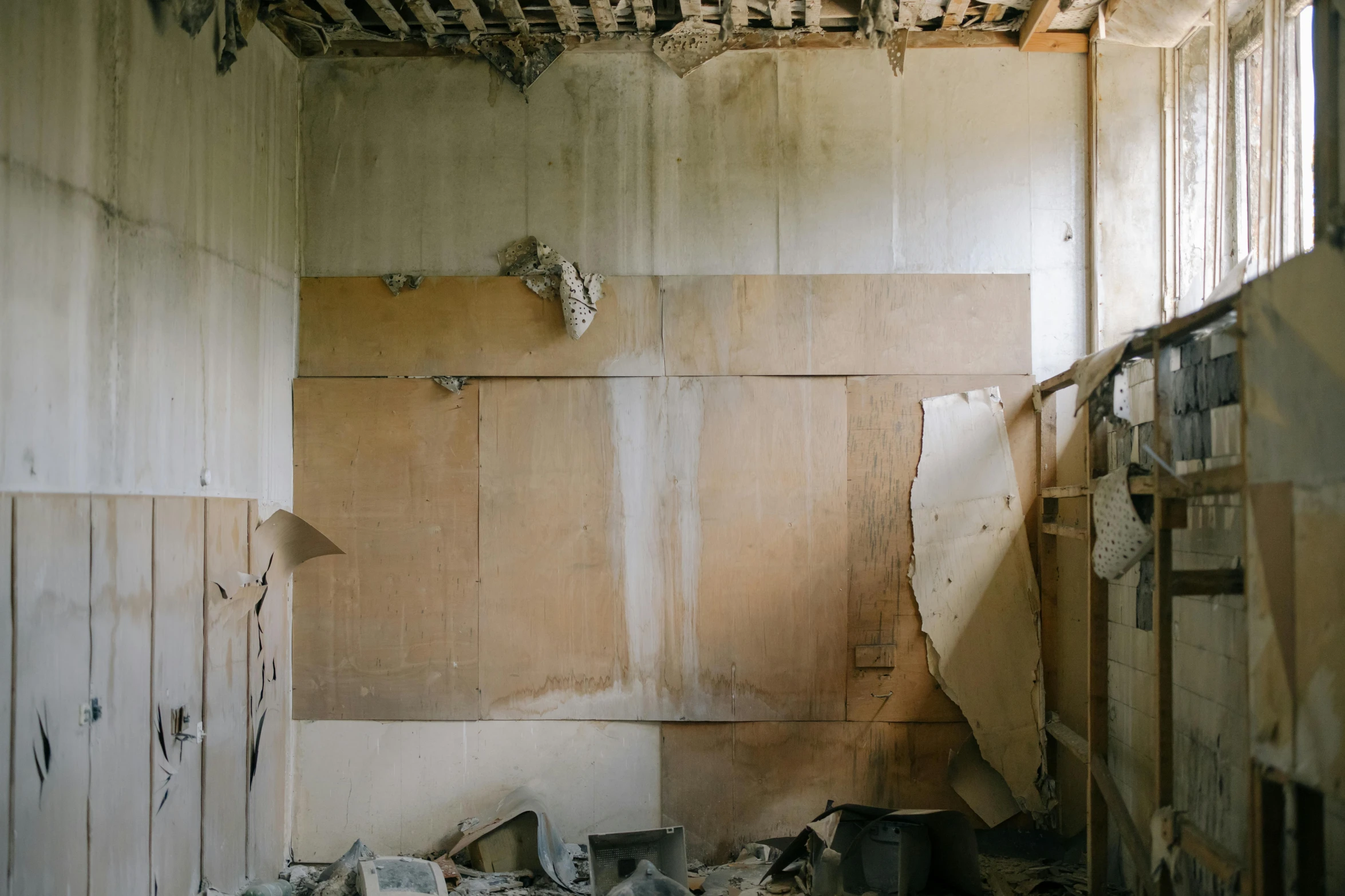 a room with very little trash, lots of debris, and a white wall