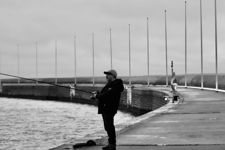 man fishing on the pier near the ocean