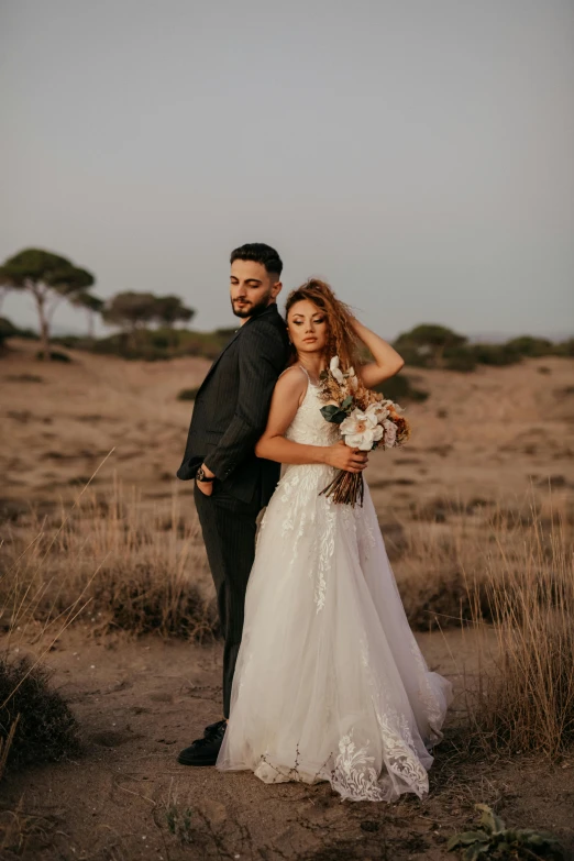 man and woman posing for the camera in an open field