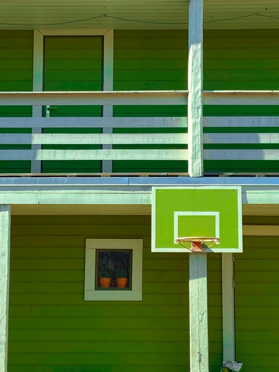 basketball hoop with the inside court up in front of an apartment building