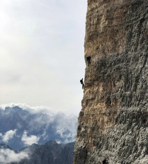 a mountain climber attempts to reach the top of a steep cliff