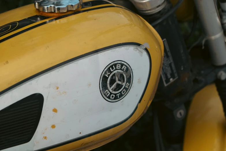 close up of a yellow motorcycle with a black emblem