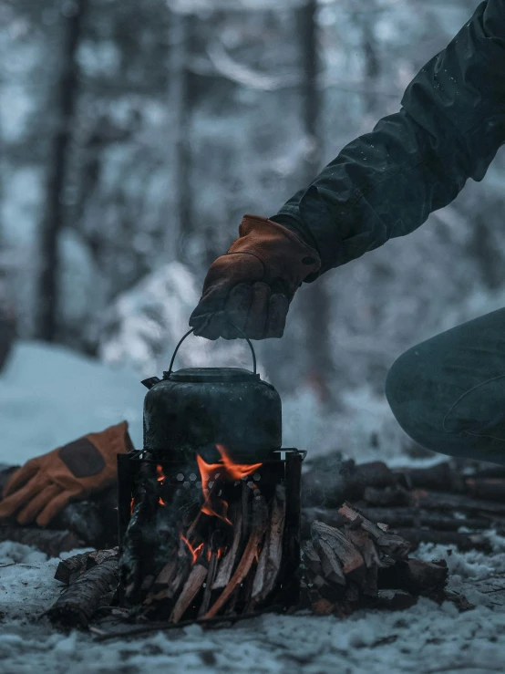 person using their camping stove to cook food