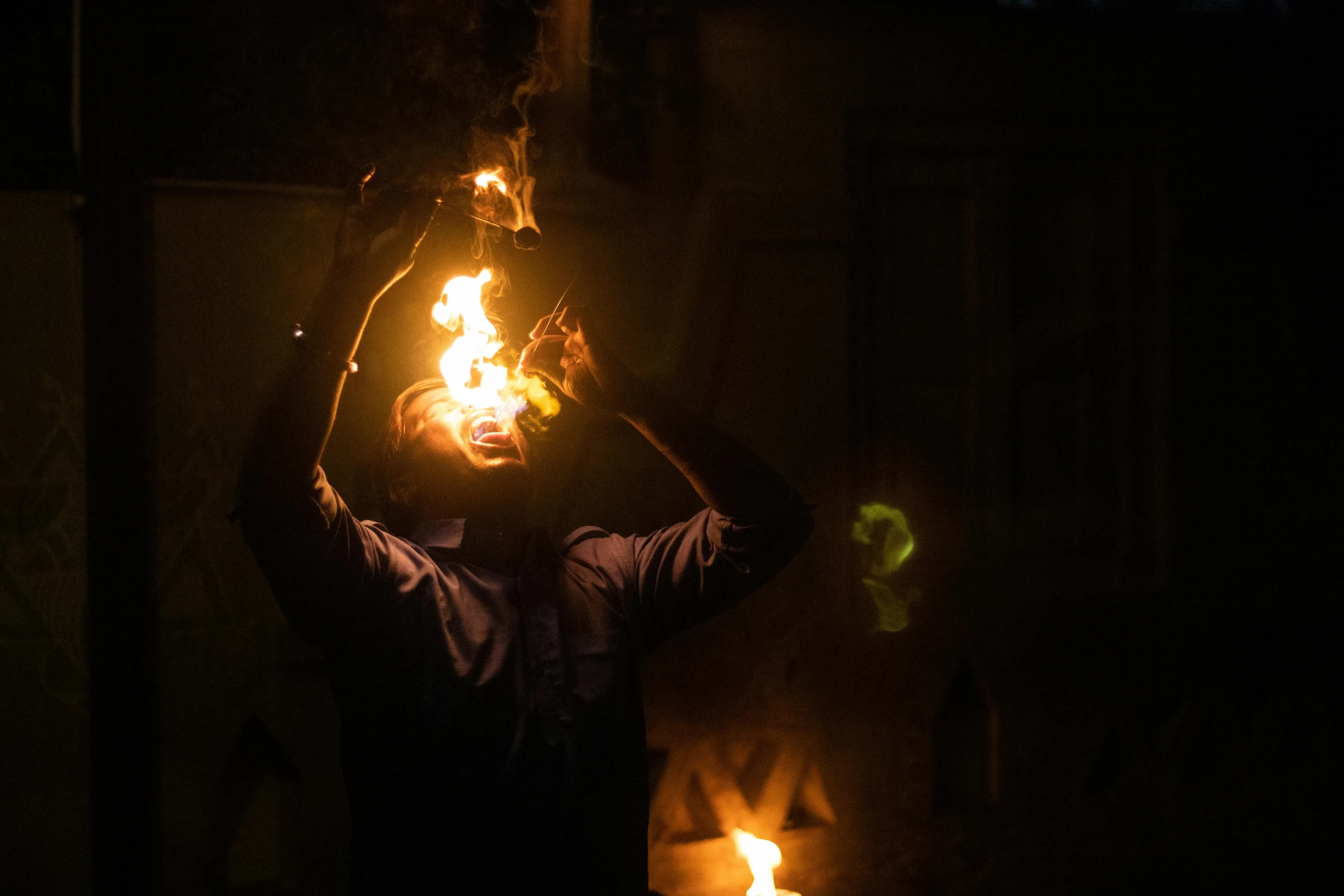 a man is holding up flames from a fire pit