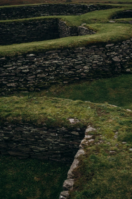 sheep grazing on grass and stone walls and dirt pathway