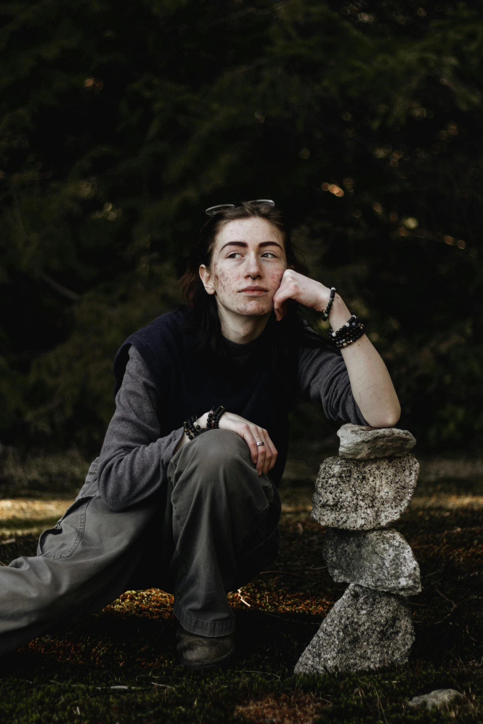 a person sits down in front of a rock