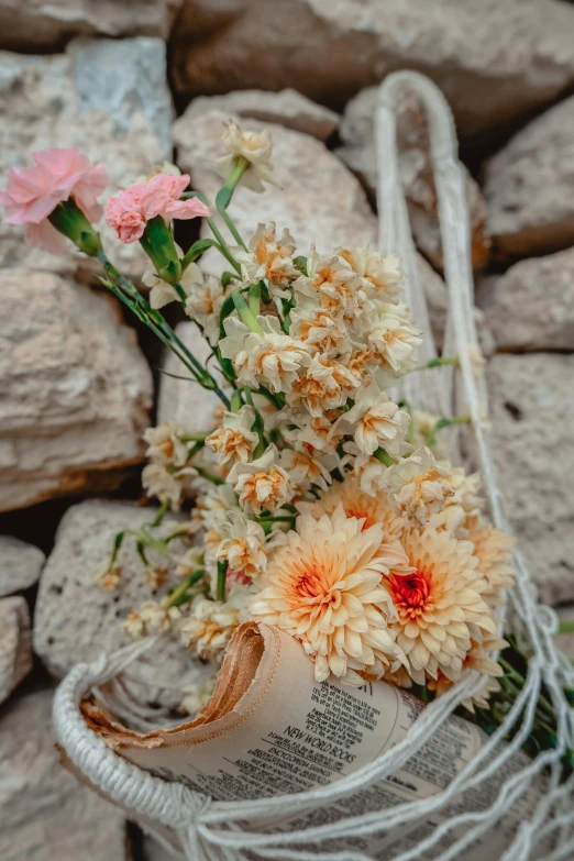 a bunch of wild flowers are in a small basket