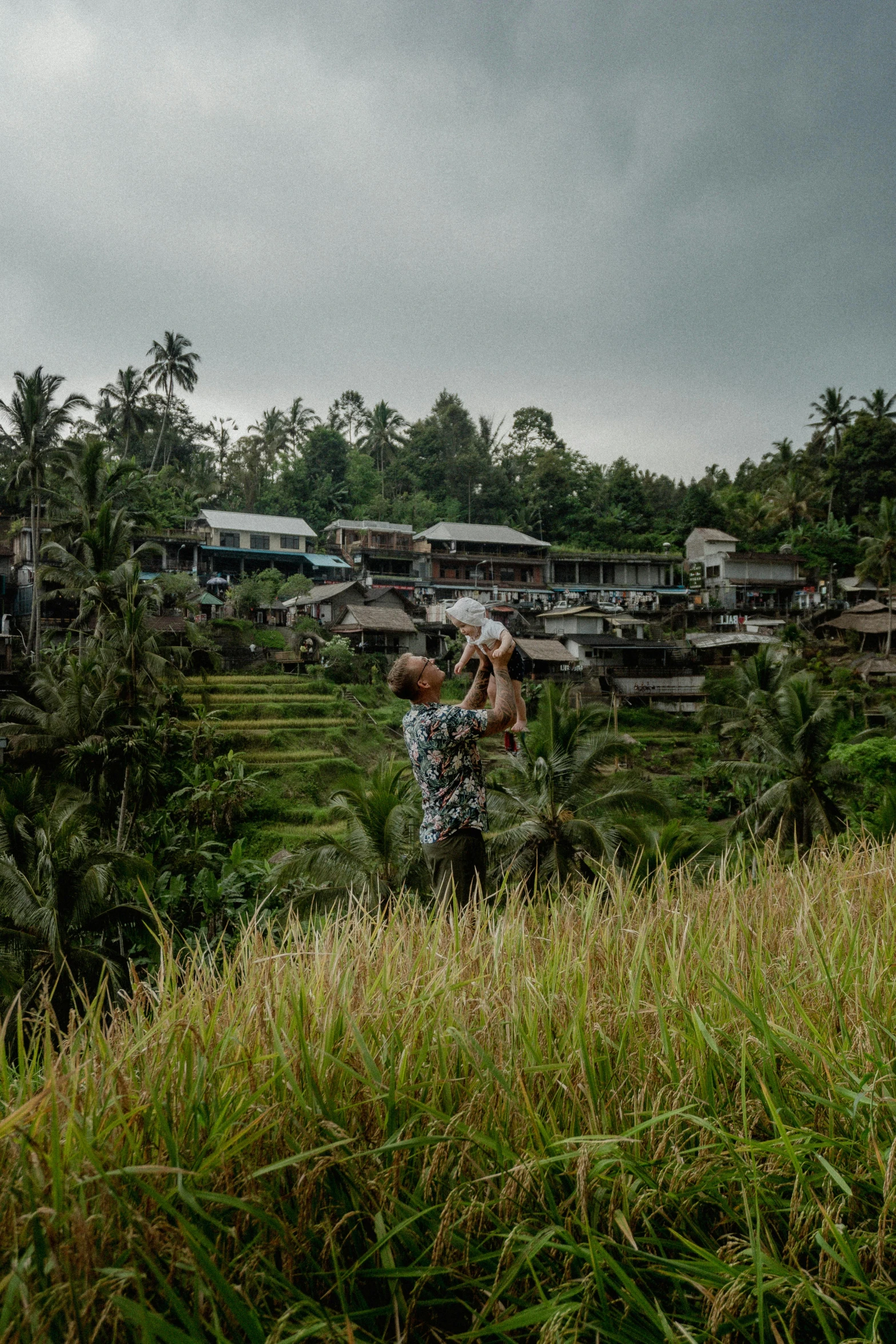 a couple looking at soing on a hill in a tropical area