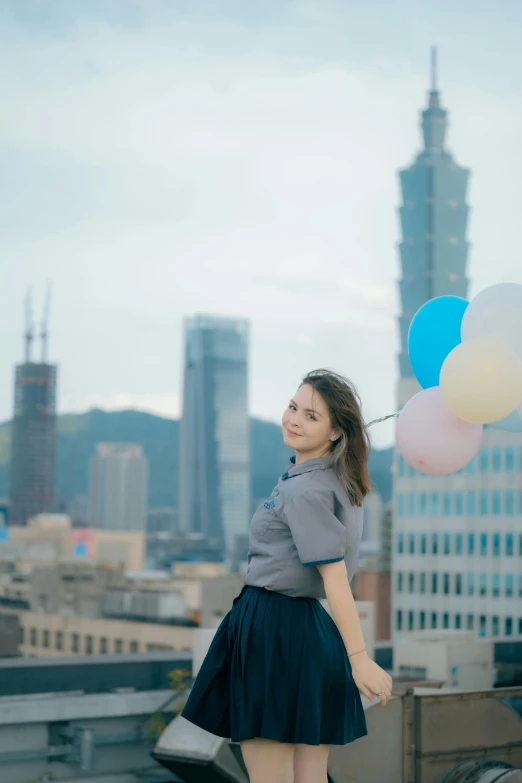 the girl is holding balloons in one hand and walking toward the camera