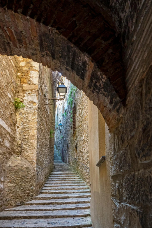 a stone - built passageway in an alley with stairs leading to the entrance