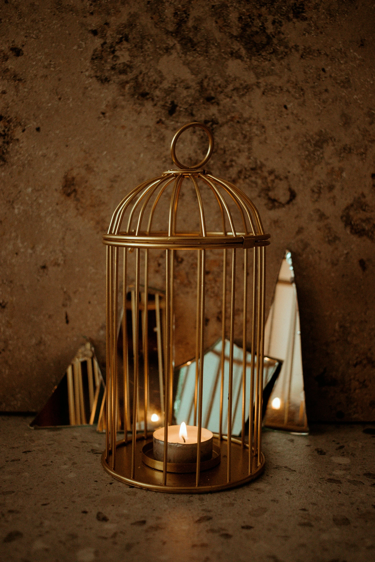 a small gold cage with candles, some towels and two small objects