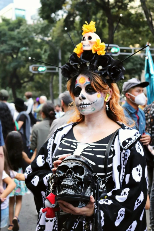 a woman is walking down a city street wearing skeletons and skulls