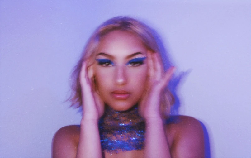 a woman with blond hair and bright blue makeup