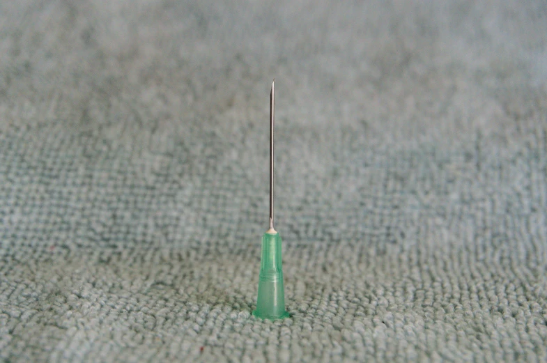 an object with one tooth and two toothpicks on the ground