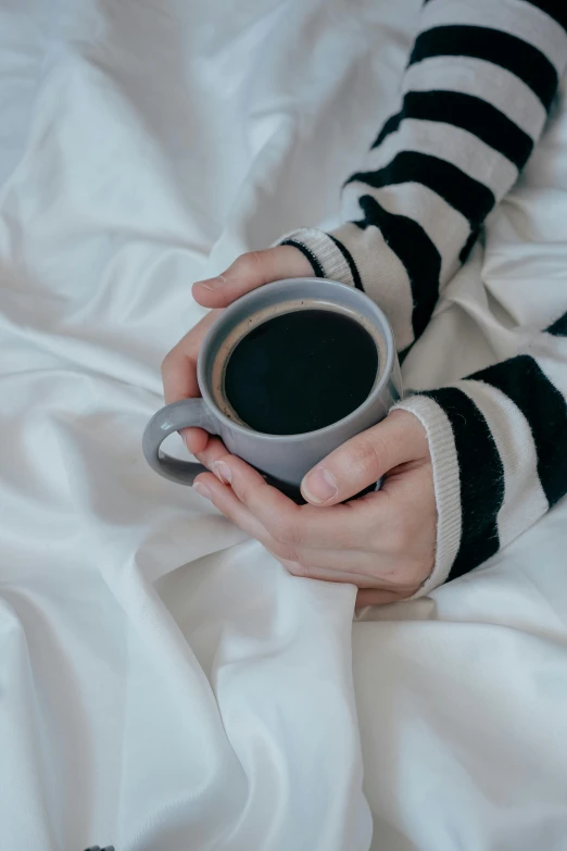 a person with striped socks holding a cup