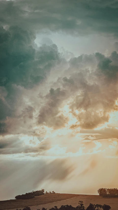 a large group of clouds is above an area of grass