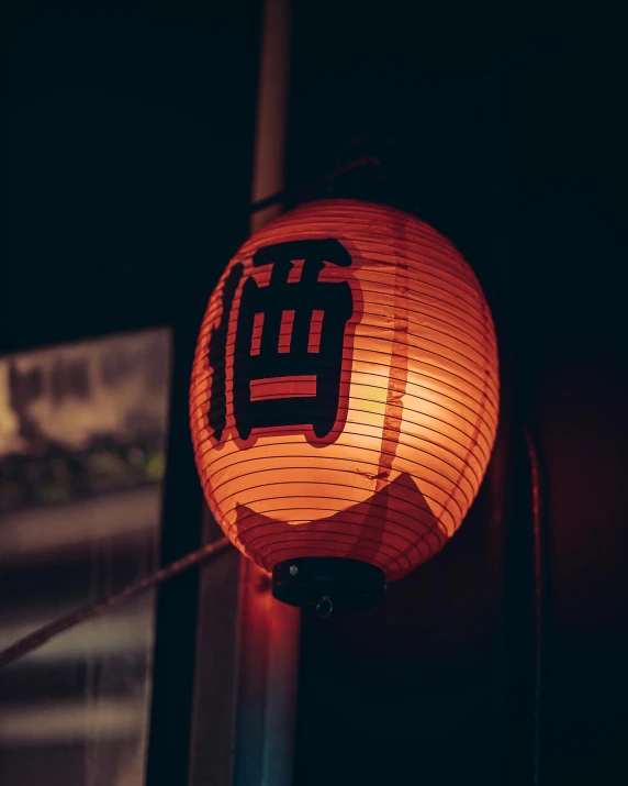 lanterns, with asian writing on them, are hanging outside