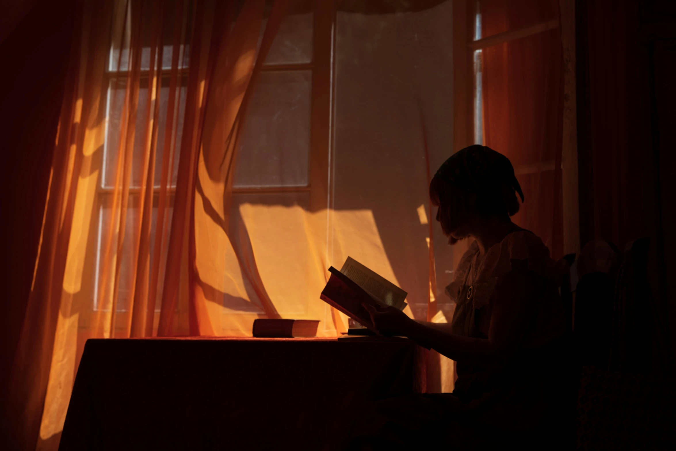 a person standing in front of a window holding a book