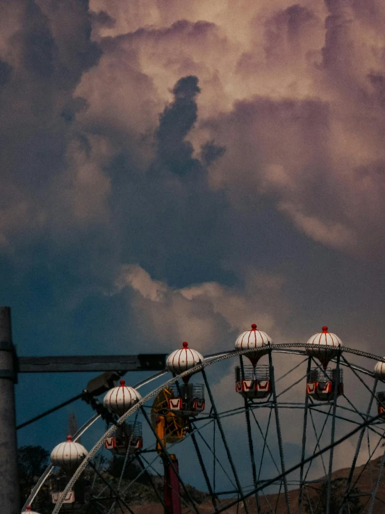 a large carnival ferris wheel with many rides under a dark sky