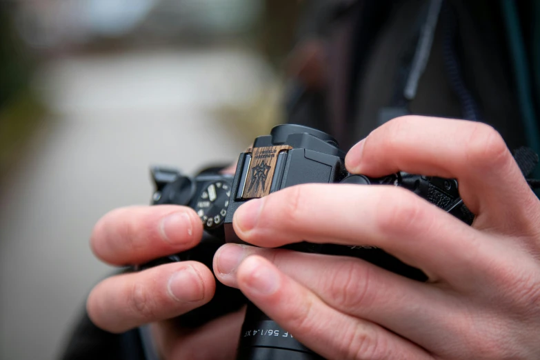 person holding camera showing its on and lens