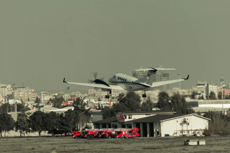 airplane flying over truck and city in distance