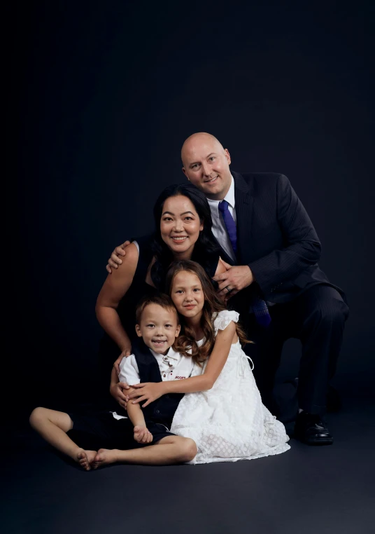 three people sitting down in front of a black background