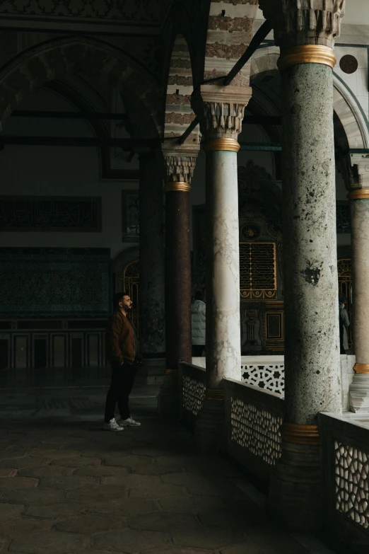 a woman standing outside a building with pillars and pillars