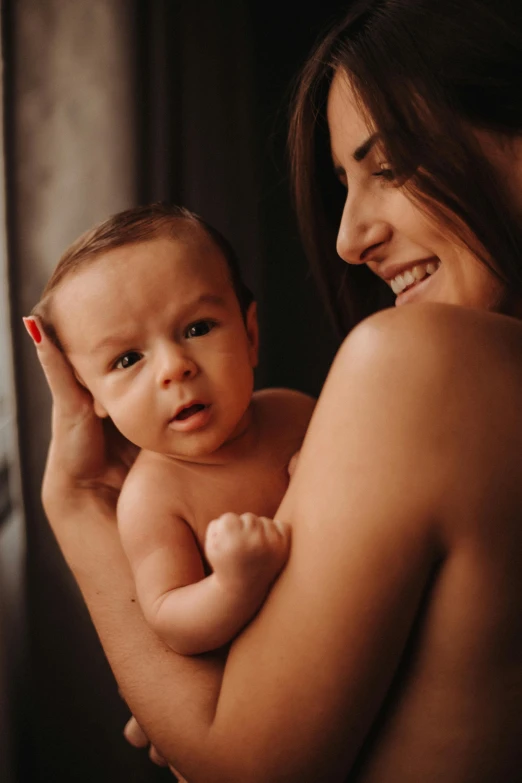 a  woman holds a baby in her arms