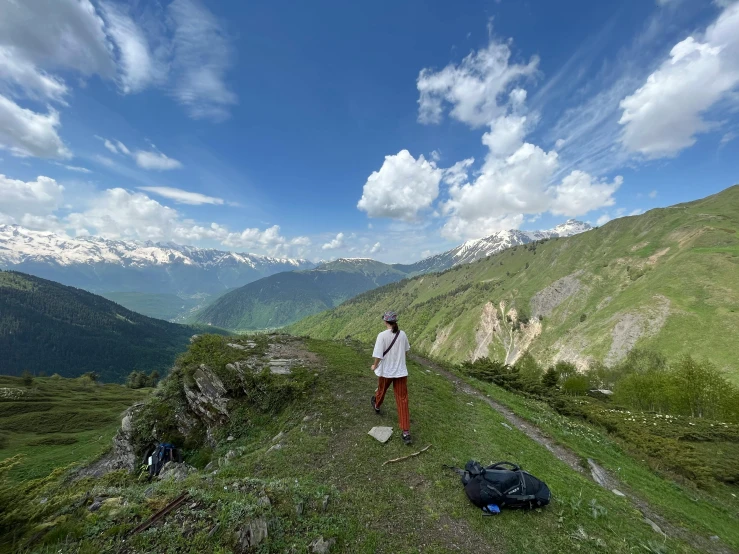 a man standing on top of a green hill