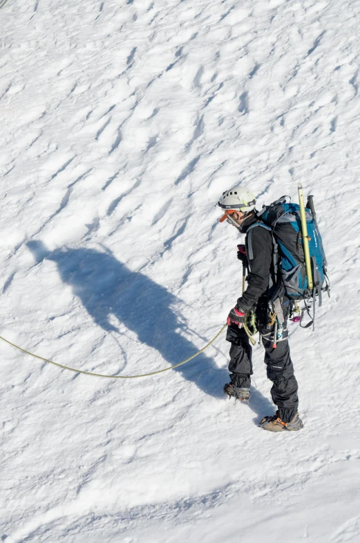 a person with a backpack walking uphill in the snow