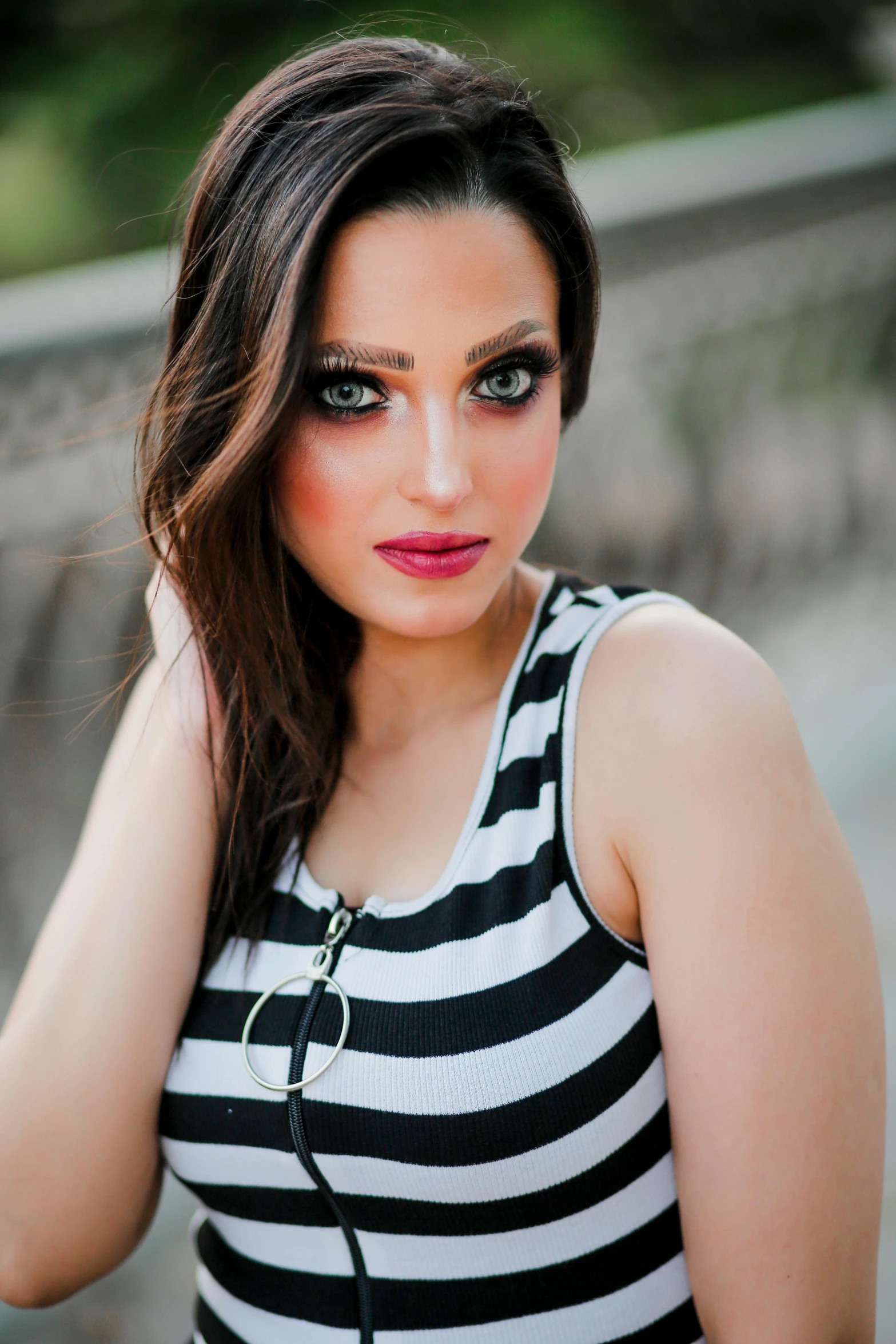 a young woman with a large eye shadow and makeup looks serious