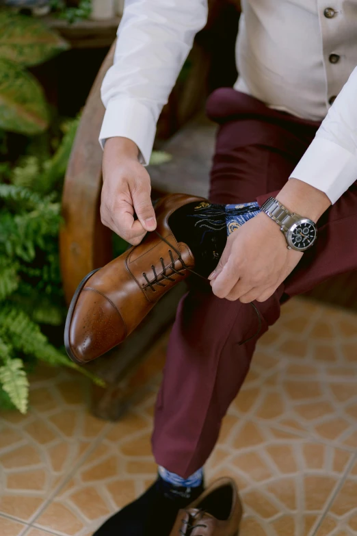 a man puts on his shoes for his groom