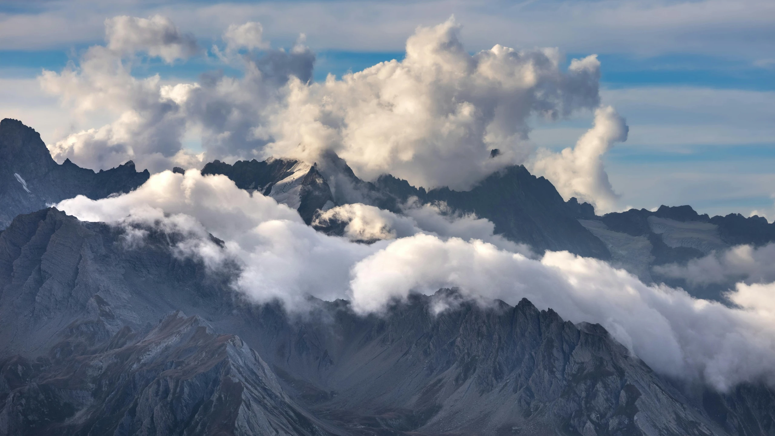 some mountains and clouds in the sky