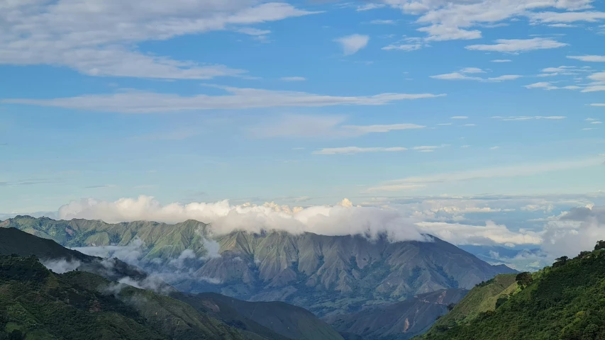 mountains on a hill covered in green and cloud