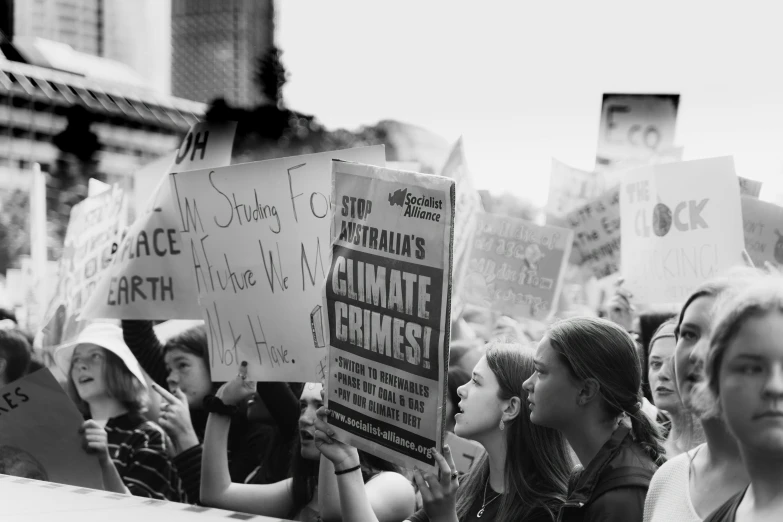 many young people standing together holding signs