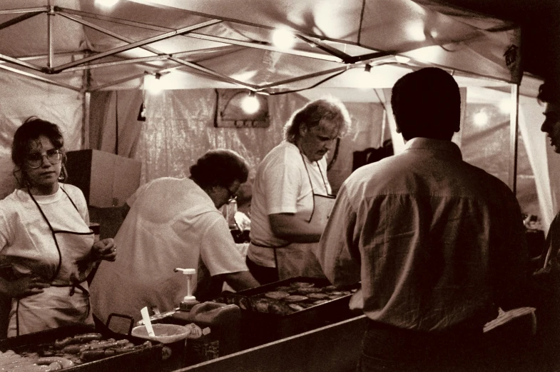 several people that are in a tent preparing food