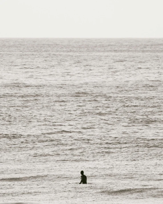 a person in the ocean sitting on a surf board