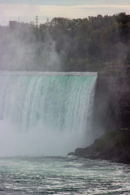 a large waterfall gushing out water onto the river