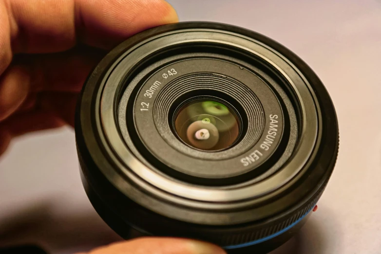 a camera lens sitting in the palm of a hand