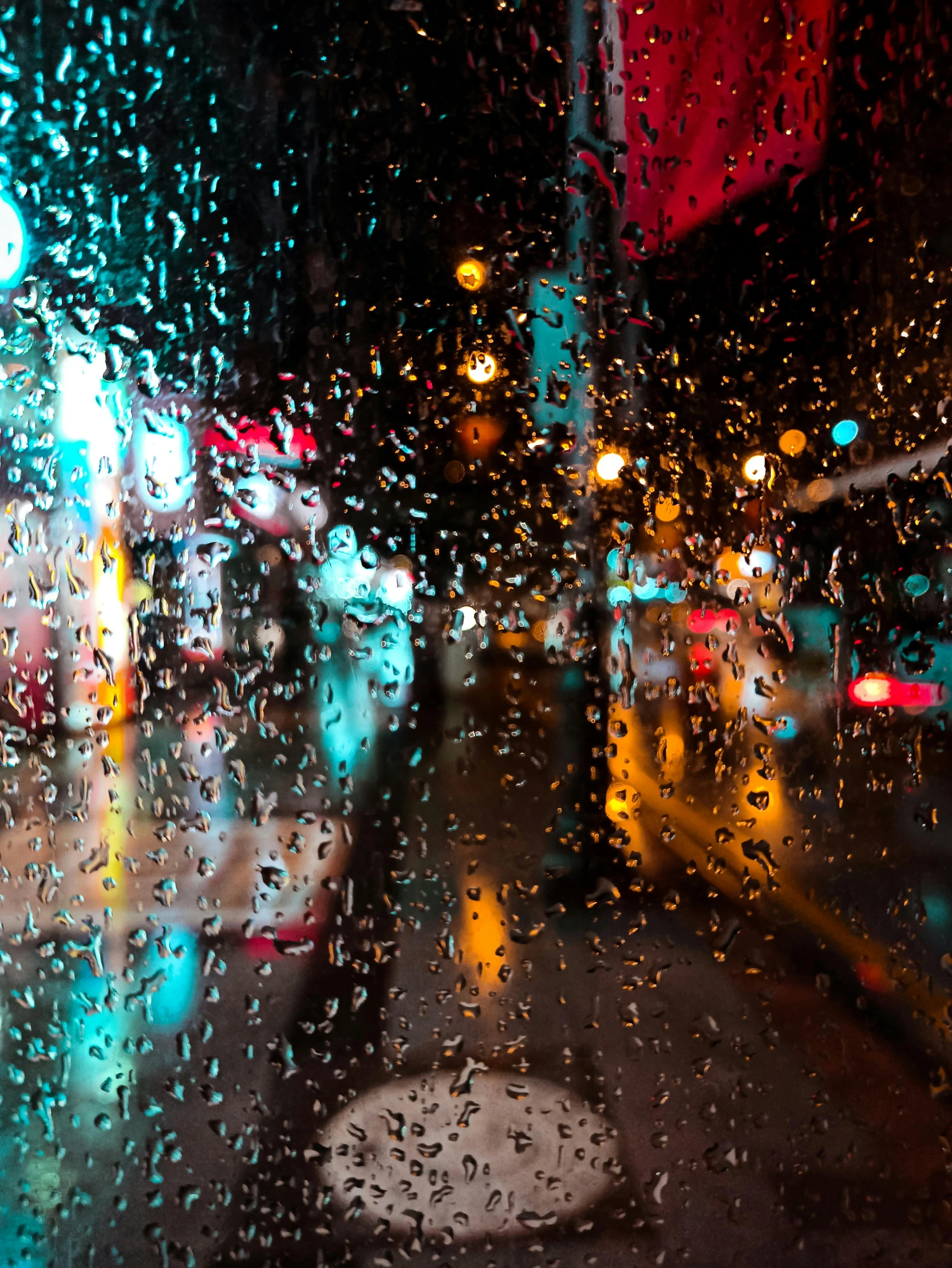 wet windshield during a rainy day with colorful traffic