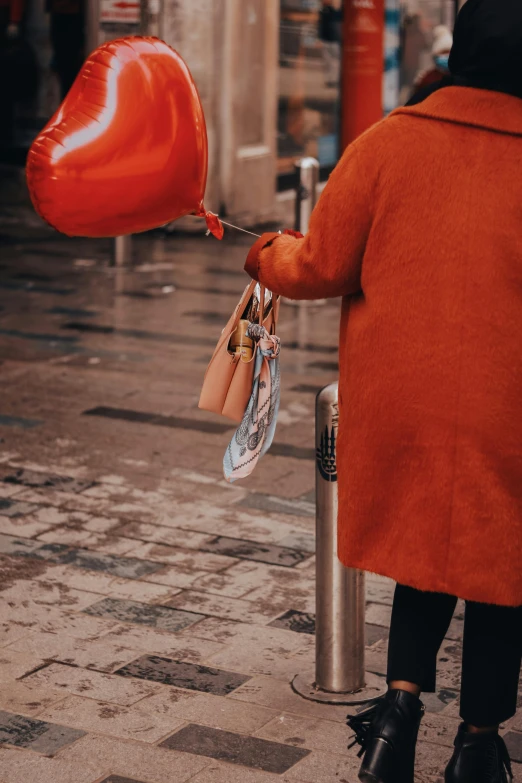 an image of someone holding balloons attached to a post