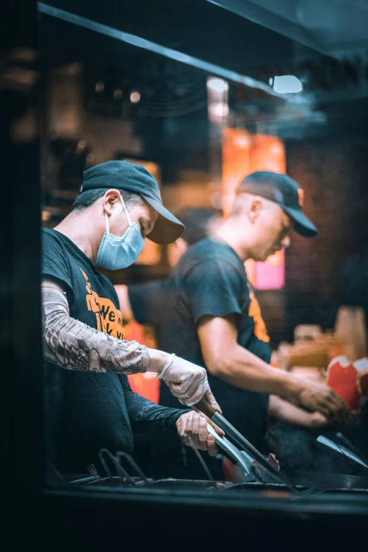 three chefs preparing meals at an outdoor restaurant