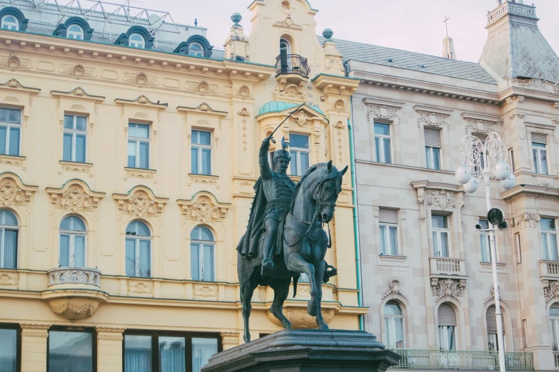 statue of a man on horseback in front of a large building