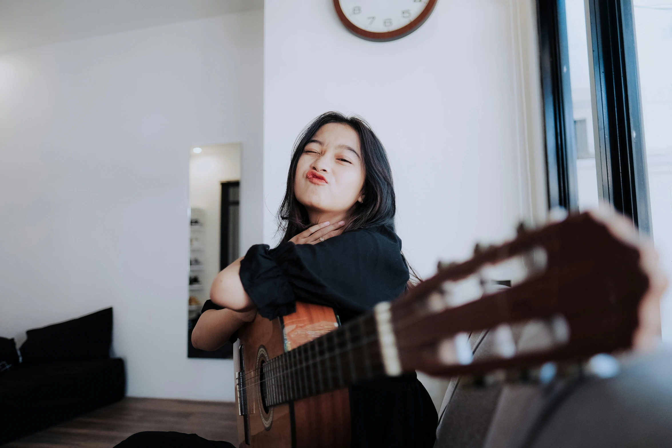 a woman playing guitar inside her home