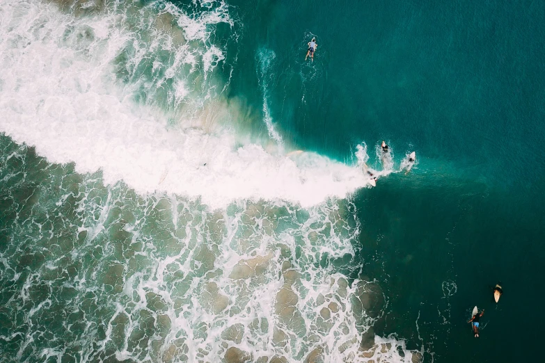 three surfers riding a wave in the ocean